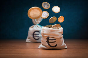 Money,Bags,With,Euro,Coins,On,Dark,Blue,Background